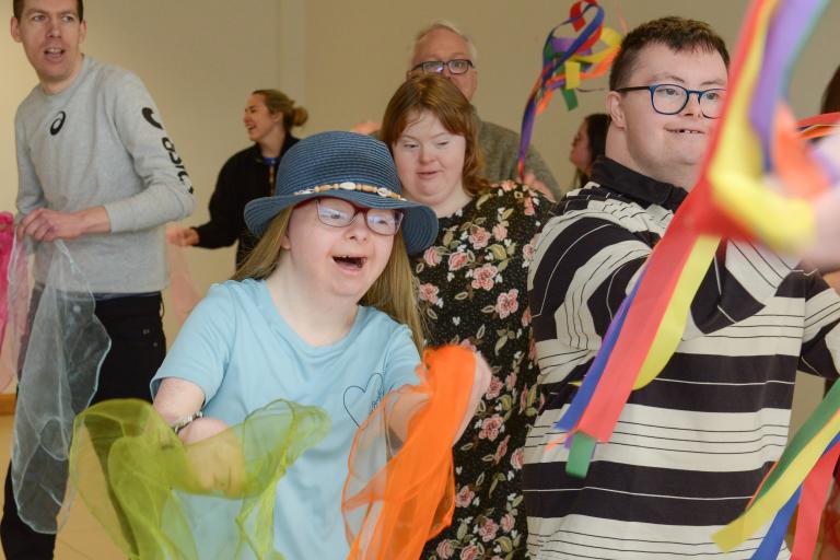 young adults dancing with coloured material