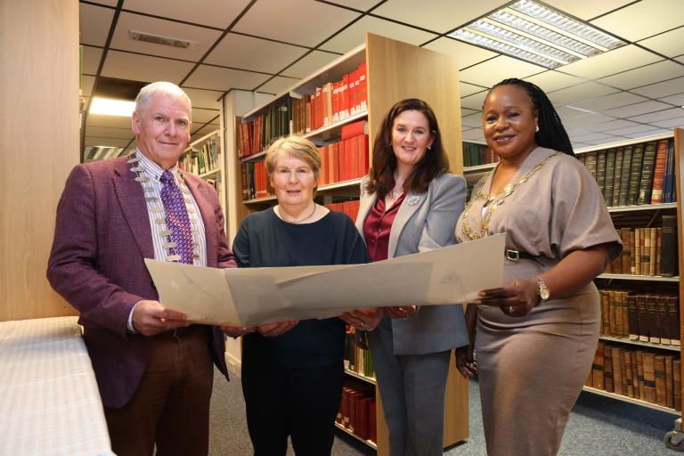 Library employees plus local dignitaries holding drawing by Peader O'Dowd