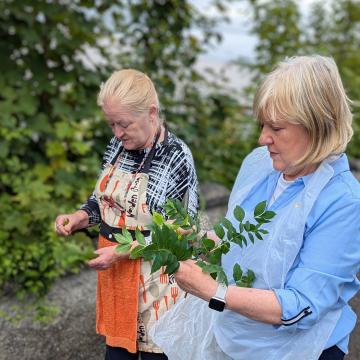 two woman holding flowers picked from the roadside