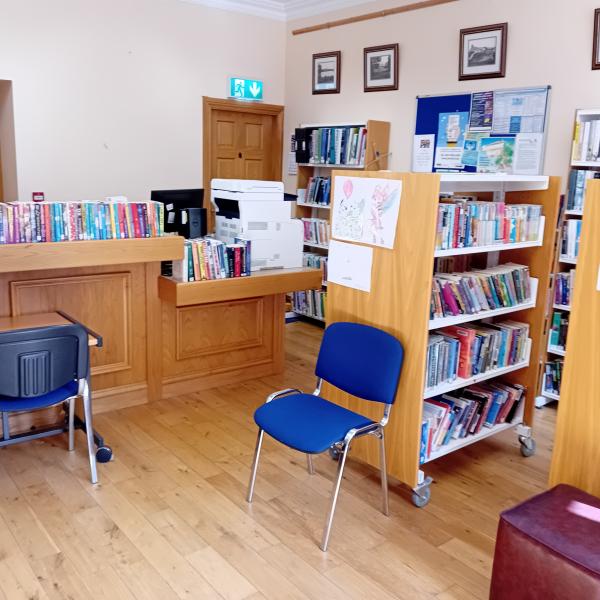 Inside of woodford library, pine floor and bookshelf with books and seats