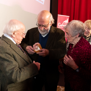 A photograph of President Michael D Higgins presenting the Ceantar Scannán award to filmmaker Bob Quinn